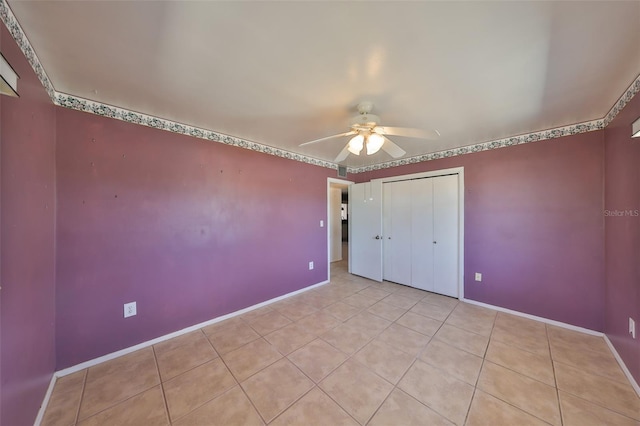 unfurnished bedroom with baseboards, a ceiling fan, light tile patterned floors, and a closet
