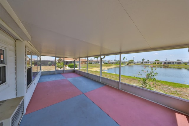 unfurnished sunroom featuring a water view and a wall mounted AC