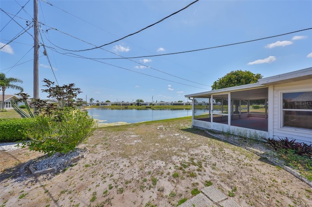 view of yard with a water view and a sunroom