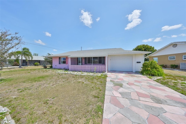 single story home featuring an attached garage, cooling unit, and a front yard