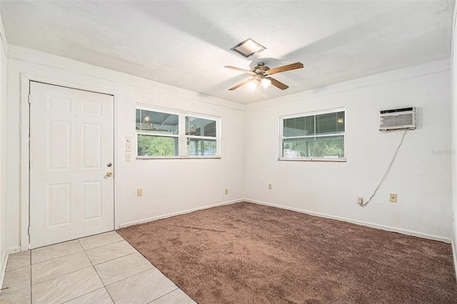 spare room featuring baseboards, ceiling fan, light carpet, and a wall mounted air conditioner