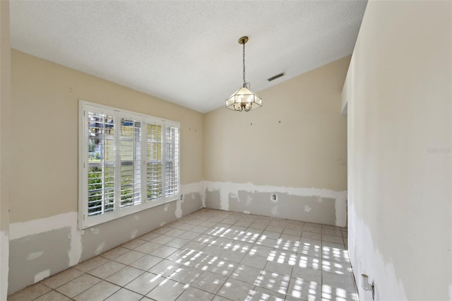 spare room featuring tile patterned flooring, vaulted ceiling, a chandelier, and visible vents