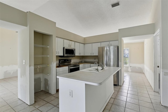 kitchen with a sink, stainless steel appliances, light tile patterned flooring, and visible vents