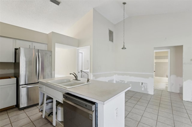 kitchen with pendant lighting, white cabinetry, a sink, light tile patterned floors, and stainless steel appliances