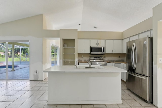 kitchen featuring light tile patterned flooring, appliances with stainless steel finishes, a sink, and vaulted ceiling