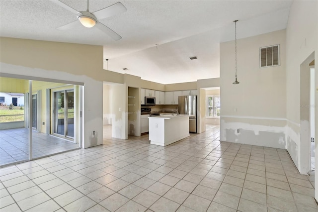 unfurnished living room featuring a ceiling fan, lofted ceiling, light tile patterned flooring, and visible vents