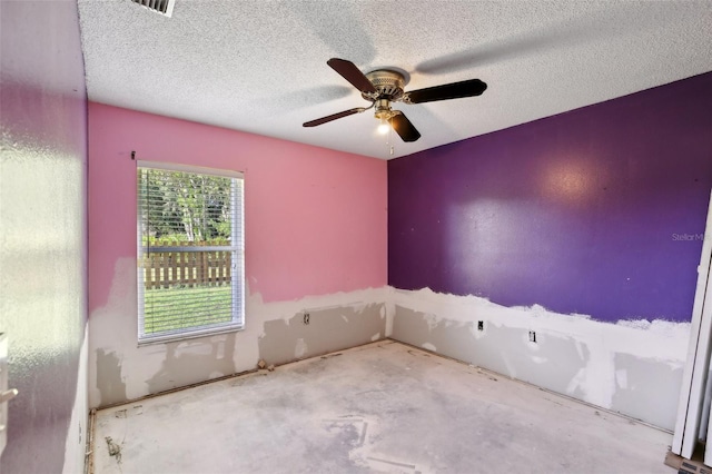 empty room with a ceiling fan, a textured ceiling, and concrete floors