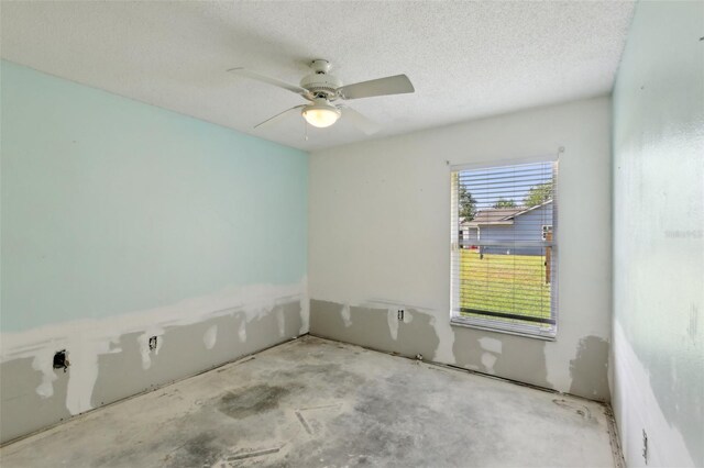 unfurnished room with a ceiling fan and a textured ceiling
