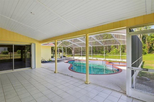 view of swimming pool featuring a patio, a lanai, and a pool with connected hot tub