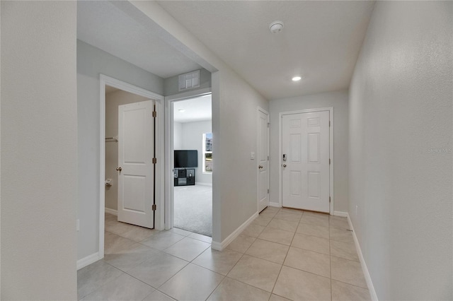 hall with light tile patterned floors, baseboards, and recessed lighting