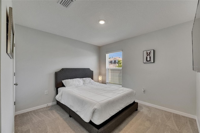 bedroom with light colored carpet and baseboards