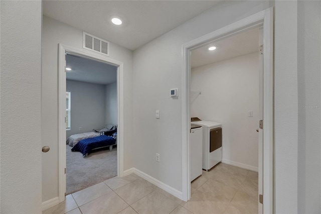 laundry area featuring separate washer and dryer, recessed lighting, light tile patterned floors, baseboards, and light carpet