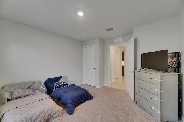 bedroom with light colored carpet and baseboards
