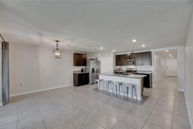 kitchen featuring appliances with stainless steel finishes, recessed lighting, light tile patterned flooring, baseboards, and a breakfast bar