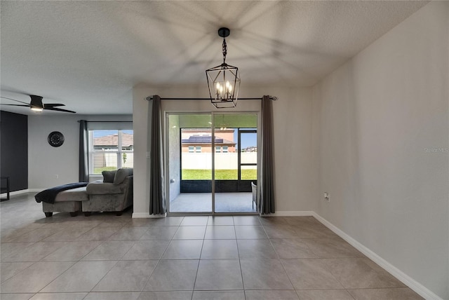 dining space featuring a textured ceiling, a chandelier, baseboards, light tile patterned floors, and ceiling fan