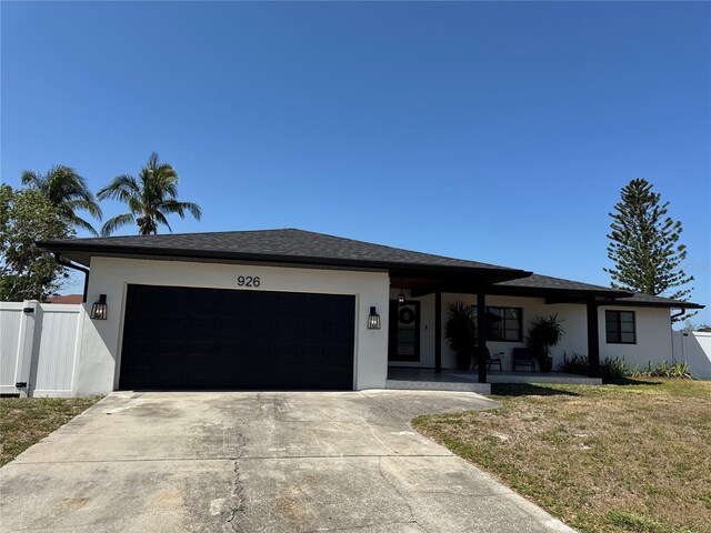 926 Eagle Ln, Apollo Beach, FL 33572 - prairie-style home with fence, a garage, stucco siding, a front yard, and driveway