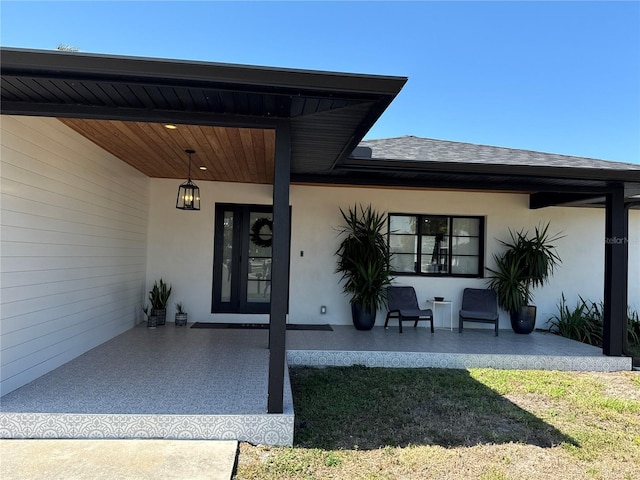 926 Eagle Ln, Apollo Beach, FL 33572 - entrance to property featuring a porch, a shingled roof, and stucco siding
