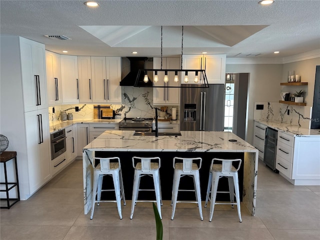 926 Eagle Ln, Apollo Beach, FL 33572 - kitchen with wine cooler, decorative backsplash, stainless steel appliances, and wall chimney exhaust hood