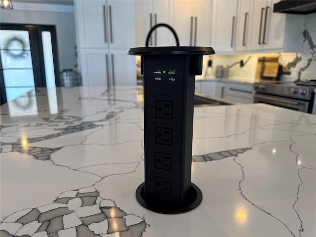 926 Eagle Ln, Apollo Beach, FL 33572 - details with under cabinet range hood, white cabinets, light stone counters, and black range with electric stovetop