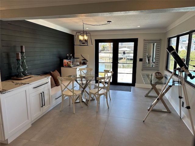 926 Eagle Ln, Apollo Beach, FL 33572 - dining area with french doors, a textured ceiling, baseboards, a chandelier, and ornamental molding