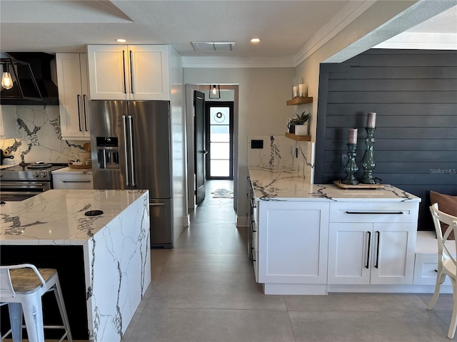 926 Eagle Ln, Apollo Beach, FL 33572 - kitchen featuring appliances with stainless steel finishes, open shelves, light stone countertops, ventilation hood, and white cabinets