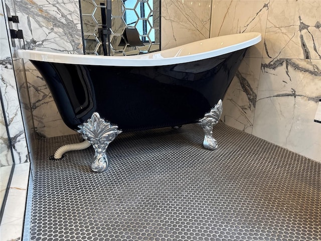 926 Eagle Ln, Apollo Beach, FL 33572 - interior space with a freestanding bath, tile walls, and stone wall