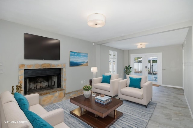 living area featuring french doors, baseboards, and a fireplace