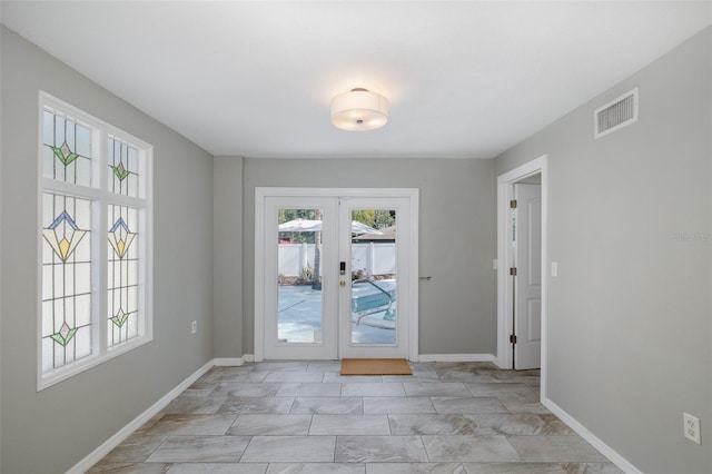 doorway with baseboards, french doors, and visible vents