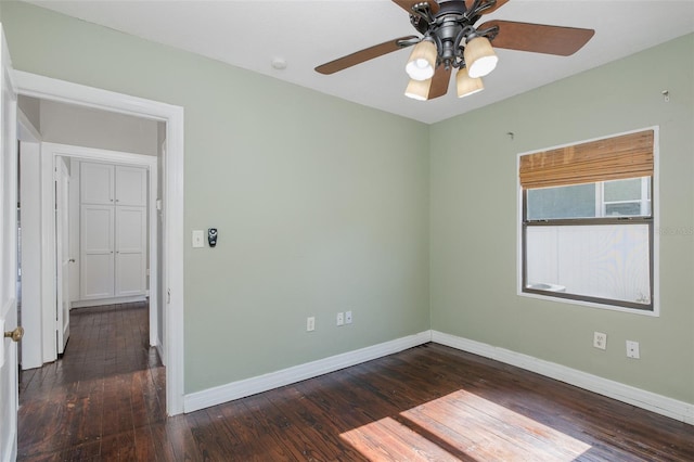 empty room with baseboards, ceiling fan, and wood finished floors