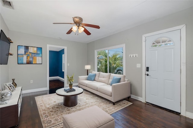 living room featuring baseboards, ceiling fan, dark wood-style flooring, and visible vents