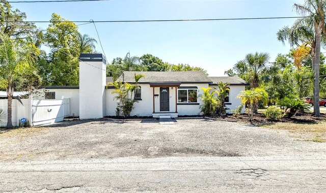 1702 E Knollwood St, Tampa, FL 33610 - view of front of property featuring a chimney, stucco siding, and fence