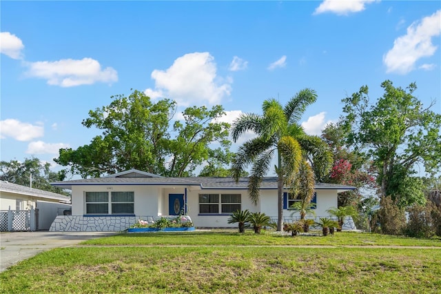 1099 7th Ave NE, Largo, FL 33770 - ranch-style house with stucco siding and a front lawn