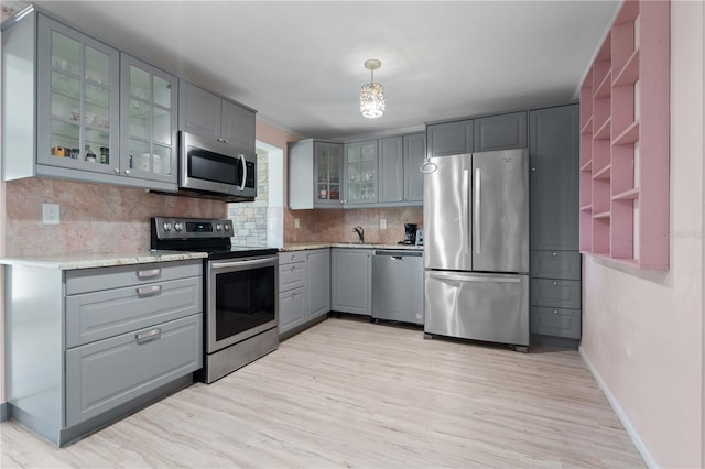 1099 7th Ave NE, Largo, FL 33770 - kitchen featuring backsplash, appliances with stainless steel finishes, gray cabinets, and light wood-style floors