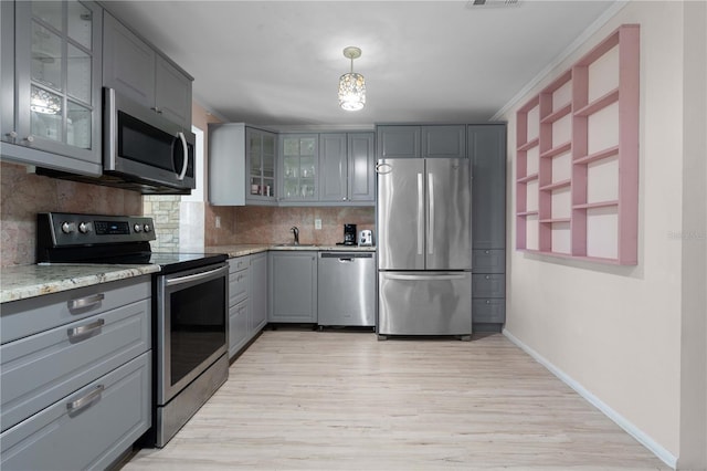 1099 7th Ave NE, Largo, FL 33770 - kitchen with baseboards, gray cabinets, decorative backsplash, and stainless steel appliances