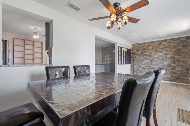 1099 7th Ave NE, Largo, FL 33770 - dining space featuring ceiling fan, visible vents, ornamental molding, and wood finished floors