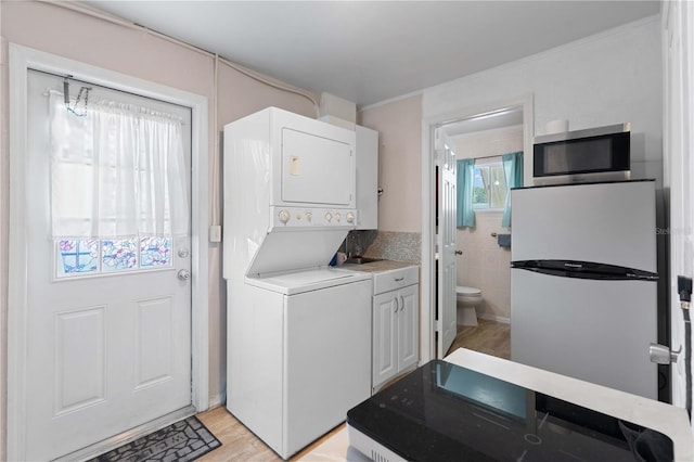 1099 7th Ave NE, Largo, FL 33770 - clothes washing area with laundry area, light wood-style flooring, and stacked washer / drying machine