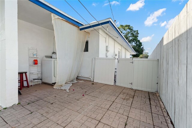 1099 7th Ave NE, Largo, FL 33770 - view of patio / terrace featuring fence, a gate, and washer / dryer