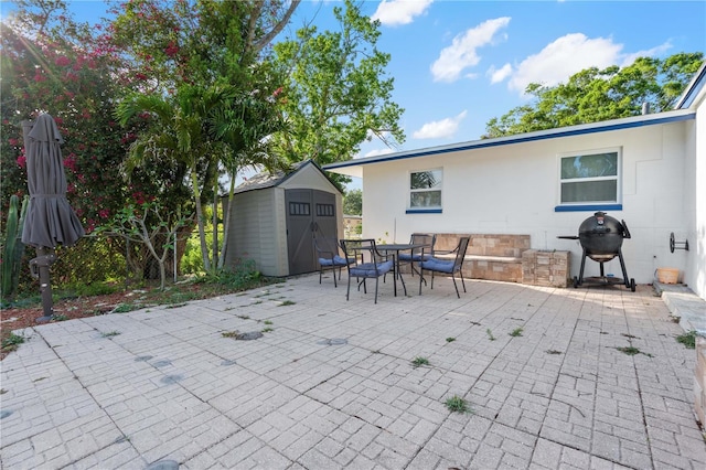 1099 7th Ave NE, Largo, FL 33770 - view of patio / terrace with outdoor dining area, an outdoor structure, a storage shed, and a grill