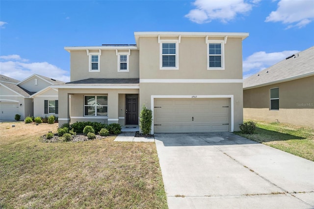 traditional home with stucco siding, concrete driveway, a front yard, and a garage