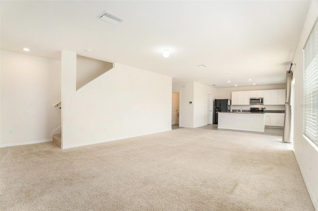 unfurnished living room featuring recessed lighting, stairs, light carpet, baseboards, and visible vents