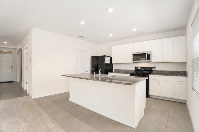 kitchen with an island with sink, black appliances, white cabinetry, visible vents, and light tile patterned flooring
