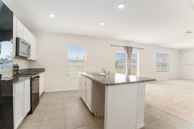 kitchen featuring stainless steel microwave, a sink, light tile patterned floors, black electric range oven, and visible vents