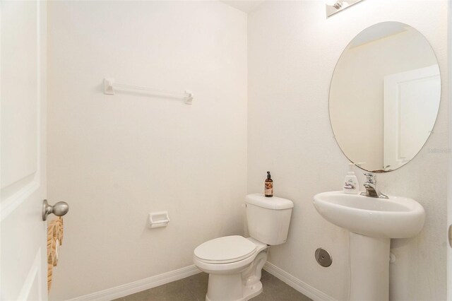 bathroom featuring toilet, tile patterned floors, and baseboards