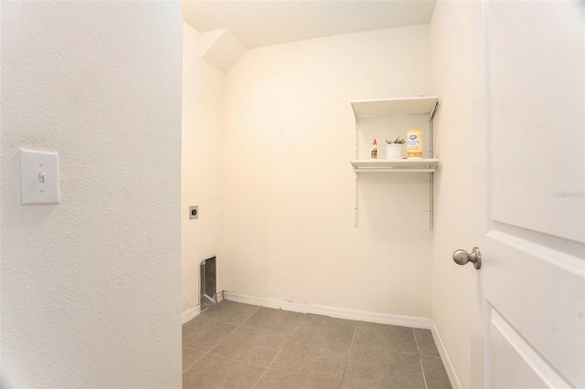laundry room featuring electric dryer hookup, baseboards, tile patterned floors, and laundry area