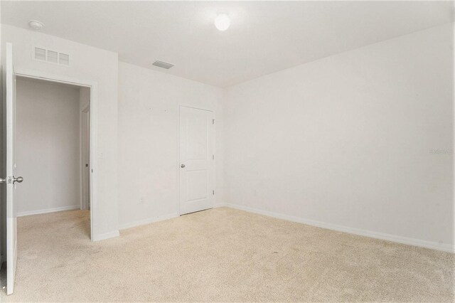 carpeted empty room featuring visible vents and baseboards