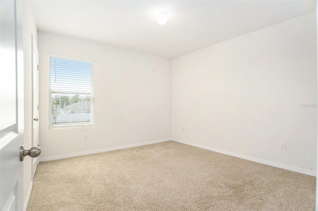 carpeted spare room featuring baseboards