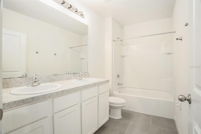 full bathroom with toilet, double vanity, a sink, and tile patterned floors