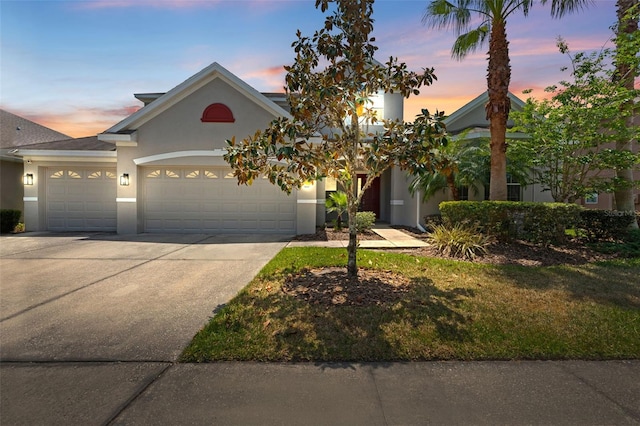view of front of home featuring a garage, stucco siding, and driveway