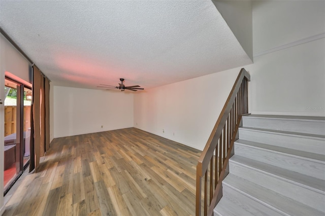 2627 2nd Ct, Palm Harbor, FL 34684 - unfurnished living room featuring a ceiling fan, a textured ceiling, wood finished floors, and stairway