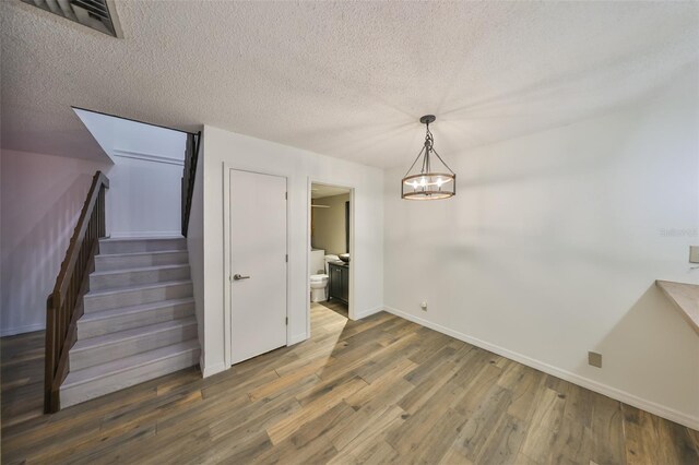 2627 2nd Ct, Palm Harbor, FL 34684 - unfurnished dining area featuring visible vents, wood finished floors, baseboards, stairway, and a textured ceiling
